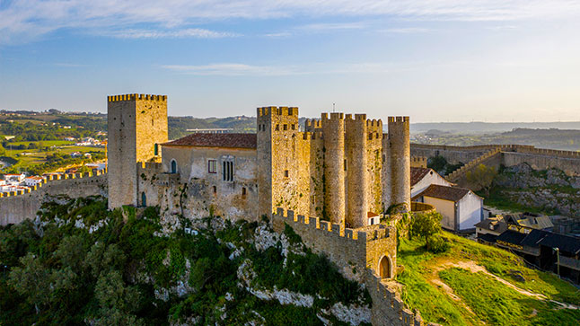 The sun is warming up the side of a medieval castle in Obidos were North Star Getaway will stop for lunch