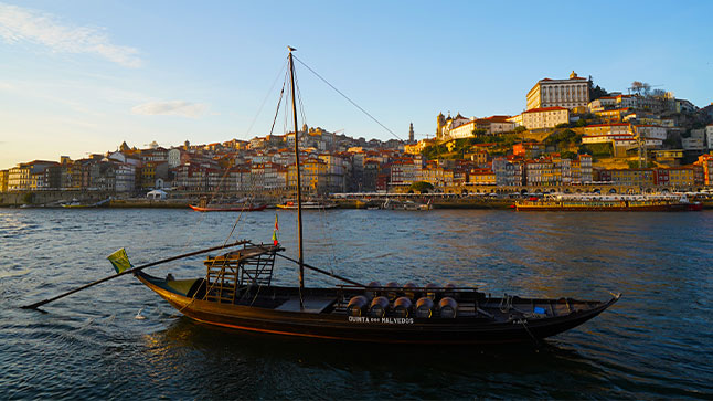 A tradition Rabelo boat park on the Douro River in Porto, Portugal at sunset.